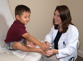 A doctor checks out a childs' feet